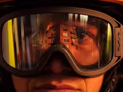 Macro lente goggle bombero reflejando edificio en llamas