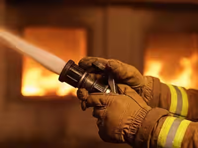 Guantes de bombero NFPA 1971 en operación de combate de incendio con manguera
