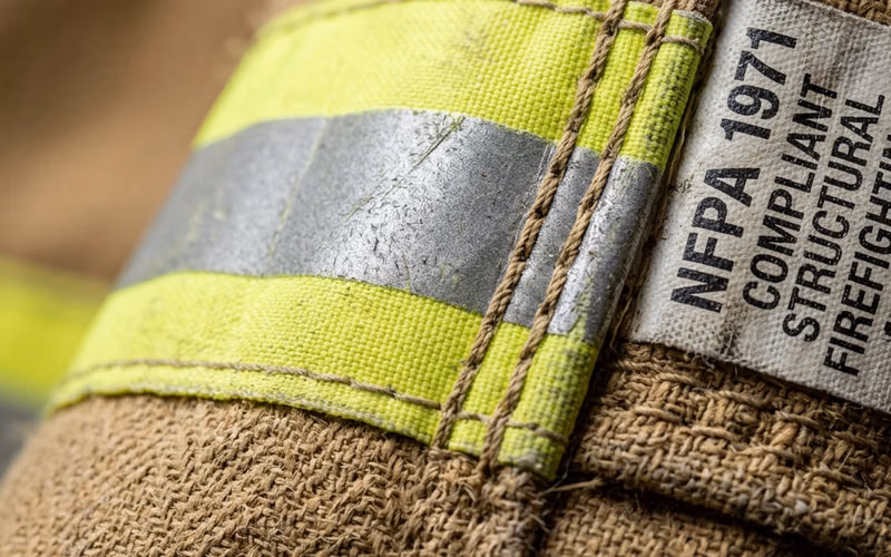 Detalle del textil Nomex y Kevlar de un traje de bombero certificado NFPA